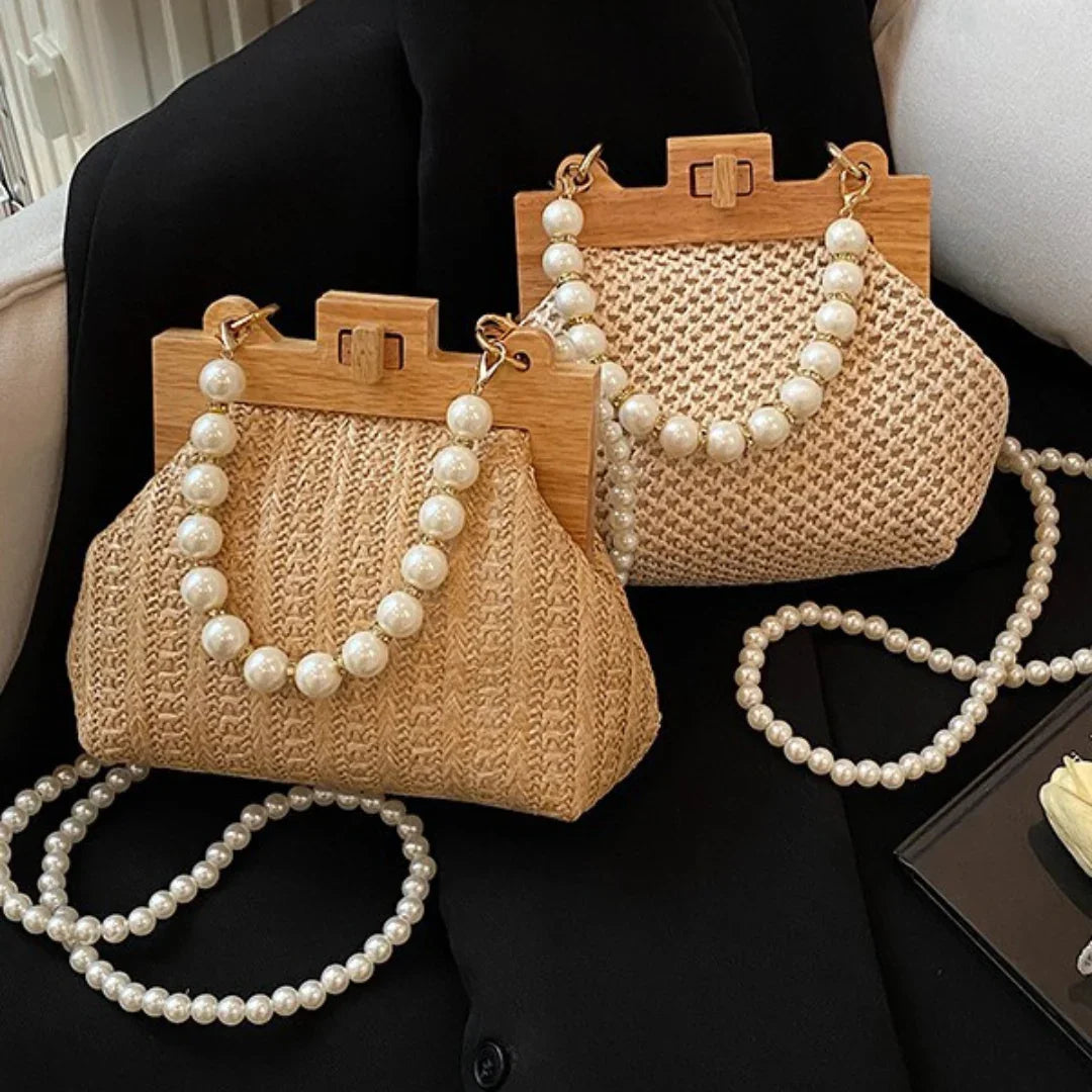 Woven straw handbags with wooden frames and pearl beaded handles on black fabric