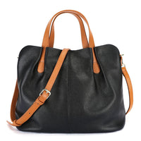 Black leather tote bag with brown handles and adjustable shoulder strap