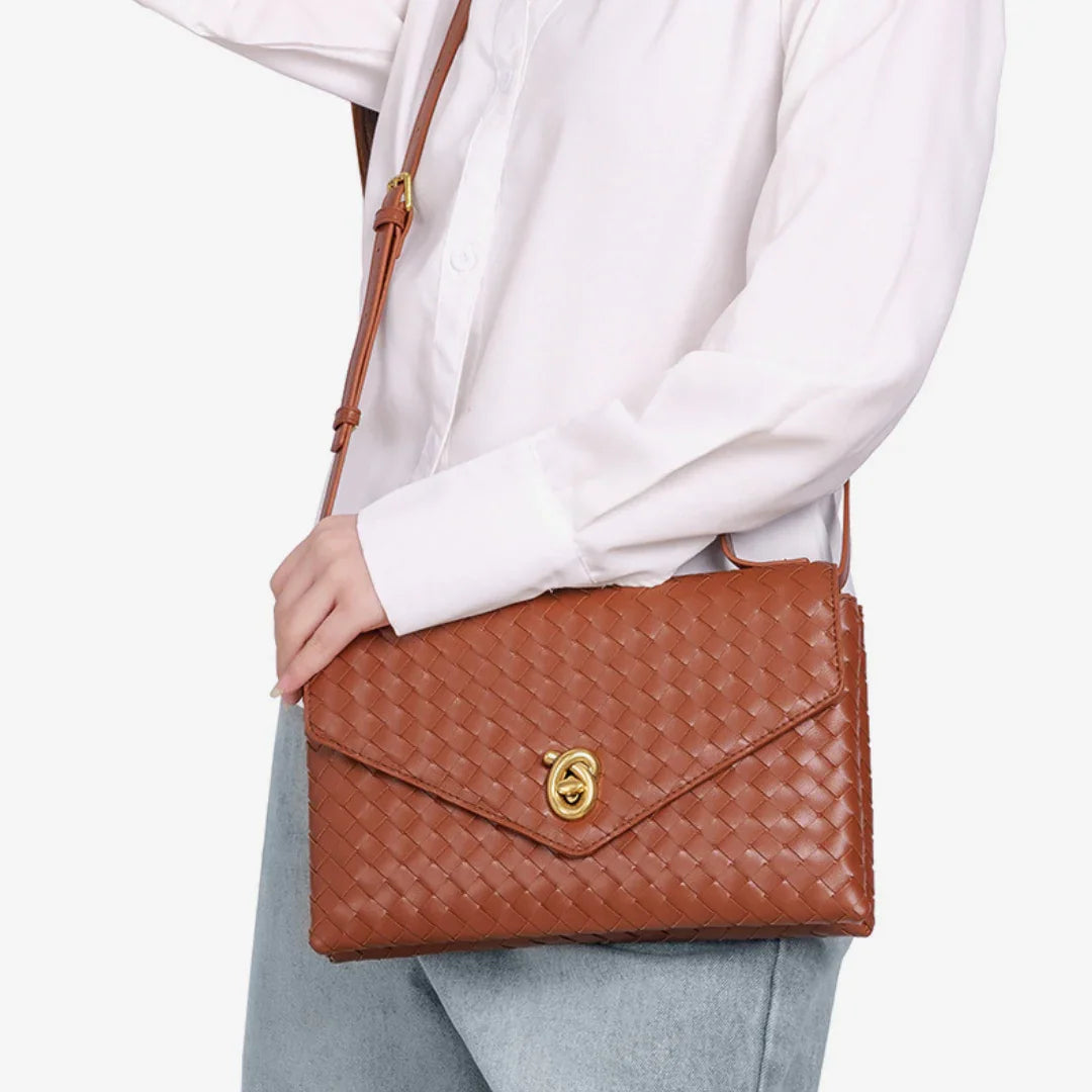 Woman wearing white shirt and jeans with brown woven leather crossbody bag