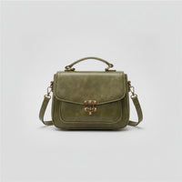 Olive green leather crossbody bag with top handle and vintage brass clasp on white background