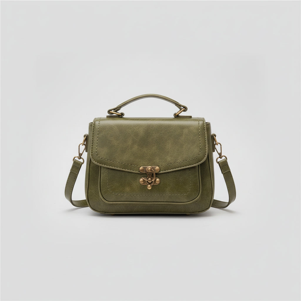 Olive green leather crossbody bag with top handle and vintage brass clasp on white background