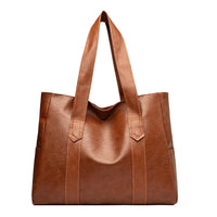 Brown leather tote bag with double handles on white background