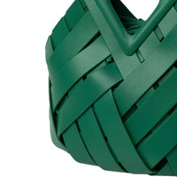 Close-up of a green woven tote bag with overlapping strips and a geometric handle