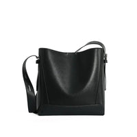 Black leather bucket bag with adjustable shoulder strap on white background