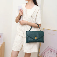 Woman in white textured shorts set holding green woven leather handbag