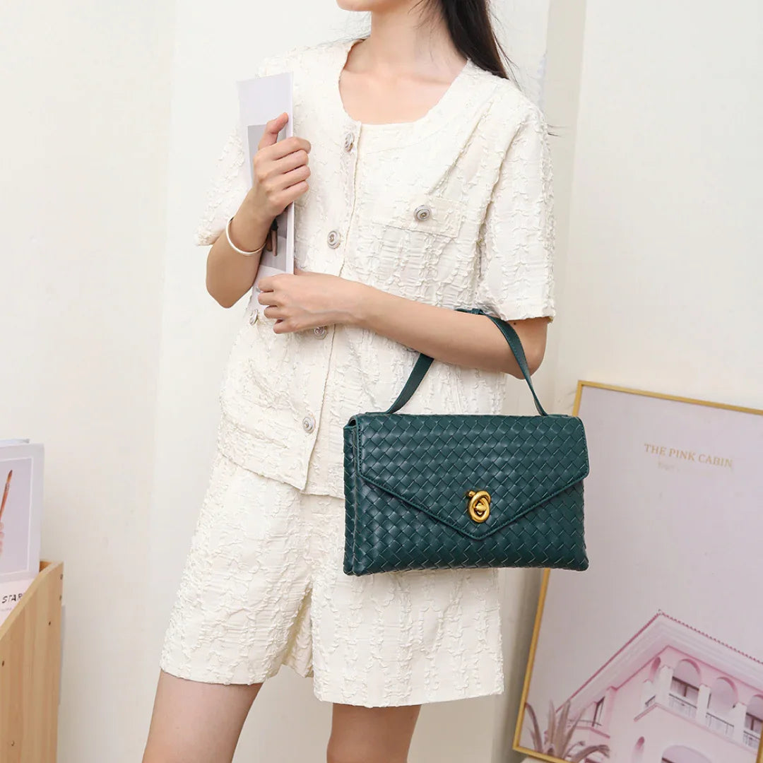Woman in white textured shorts set holding green woven leather handbag
