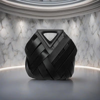 Modern black woven handbag with triangular handle on marble background
