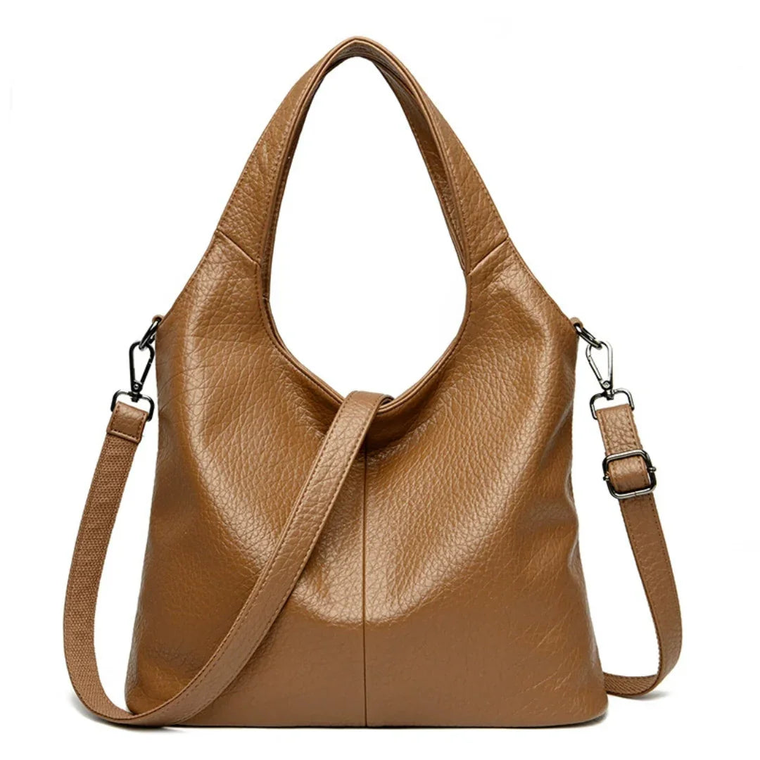 Brown leather tote bag with detachable shoulder strap and textured finish on white background