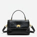 Black leather handbag with gold hardware and top handle on a white background