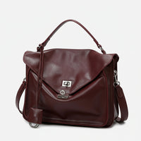 Burgundy leather satchel handbag with silver clasp, top handle, and detachable strap