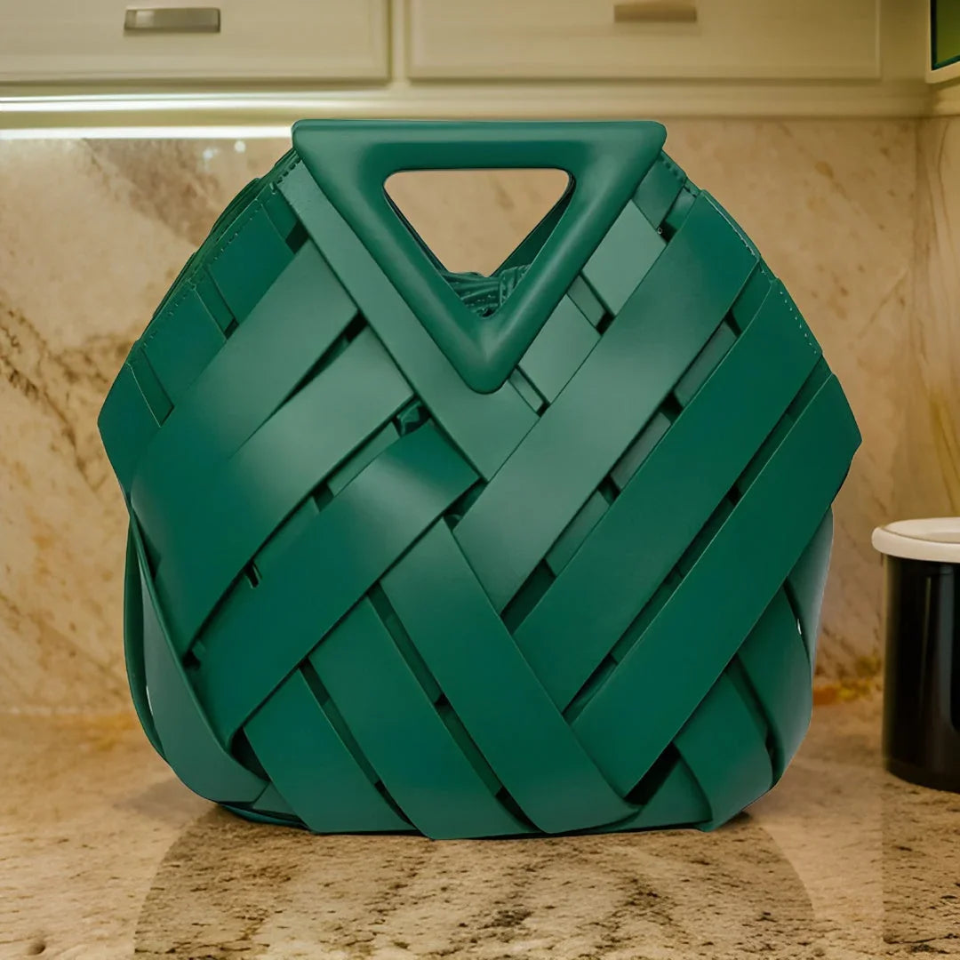 Green woven handbag with triangular handle on marble kitchen countertop