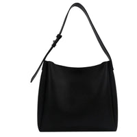 Minimalist black leather shoulder bag with adjustable strap on white background