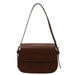 Brown leather shoulder bag with flap closure on white background