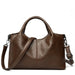 Brown leather handbag with shoulder strap and top handles on white background