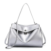 Silver leather handbag with shoulder strap, top flap, and turn-lock closure on white background.