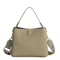 Taupe leather handbag with gold hardware and detachable shoulder strap on white background
