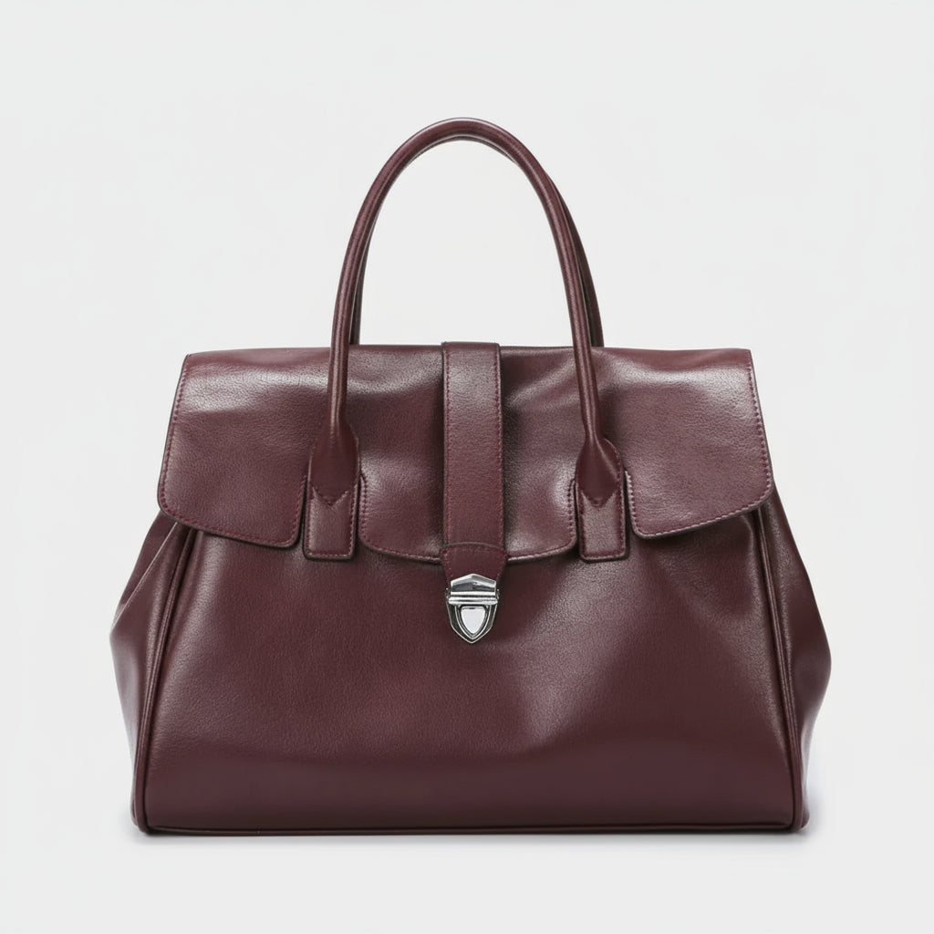 Burgundy leather handbag with top handles and silver clasp on white background