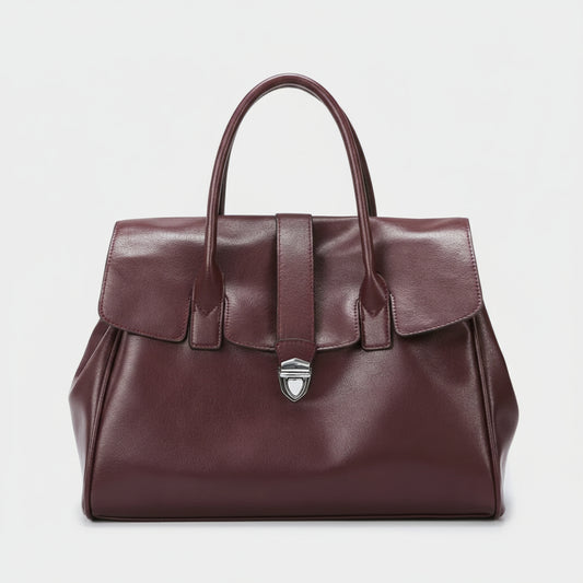 Burgundy leather handbag with top handles and silver clasp on white background