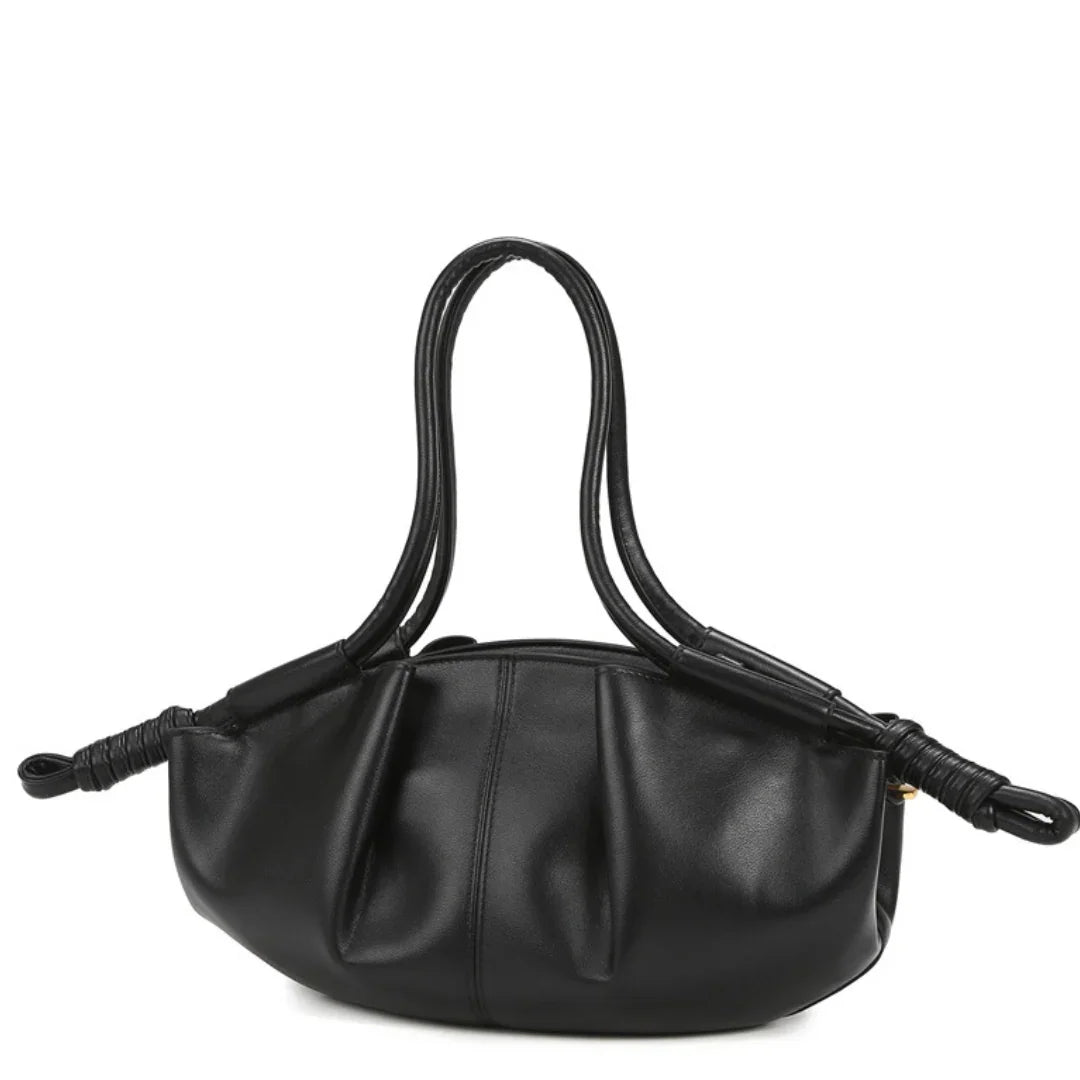 Black leather handbag with double handles and knotted ends against white background
