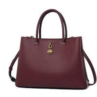 Elegant burgundy leather handbag with gold accents and dual handles, fashion accessory