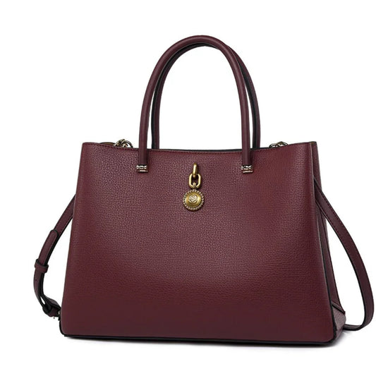 Elegant burgundy leather handbag with gold accents and dual handles, fashion accessory