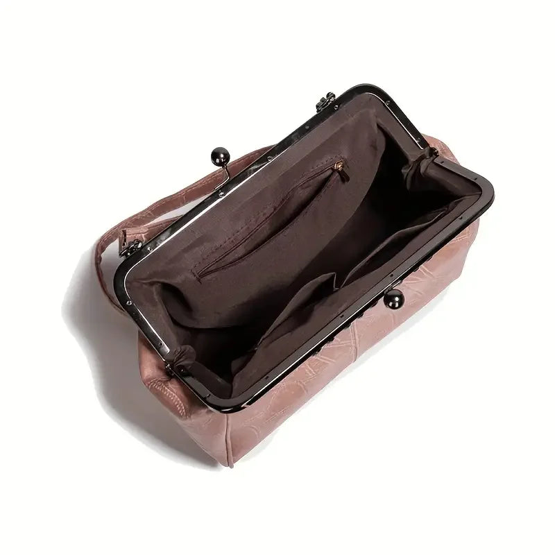 Open pink leather handbag with kiss lock frame and brown fabric interior compartments