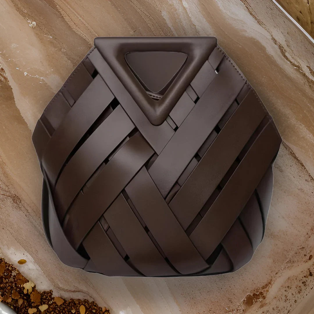 Dark brown woven leather handbag on marble surface, modern geometric purse design