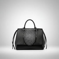 Black leather handbag with snake print panel and chain handle on white background