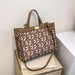 Brown and white tote bag with geometric FE pattern on a beige surface