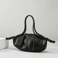 Black leather handbag with ruched design and double handles on a white background