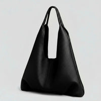 Minimalist black leather tote bag with wide handles on a plain light background