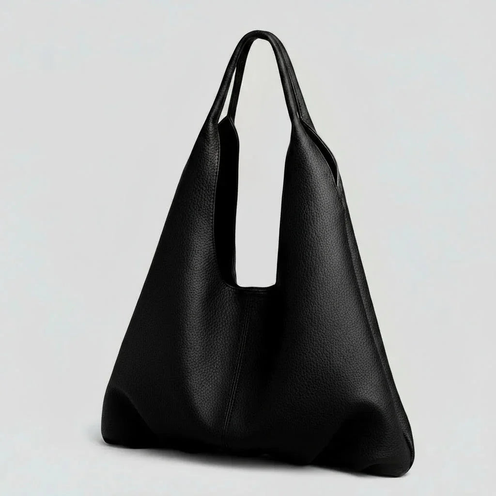Minimalist black leather tote bag with wide handles on a plain light background