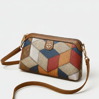 Colorful geometric patchwork leather crossbody bag with brown strap on beige background