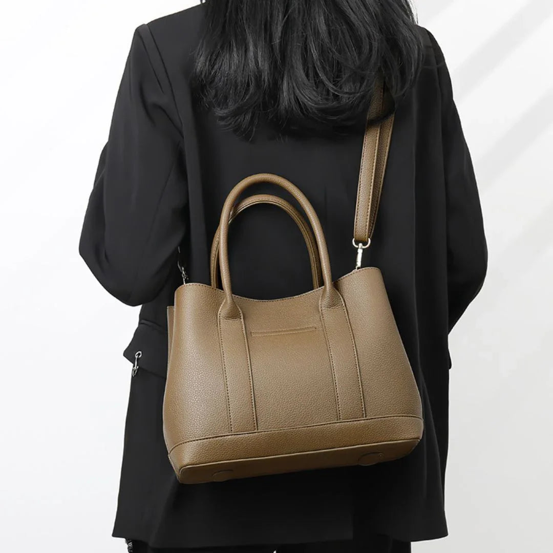Woman in black blazer with brown leather tote crossbody bag