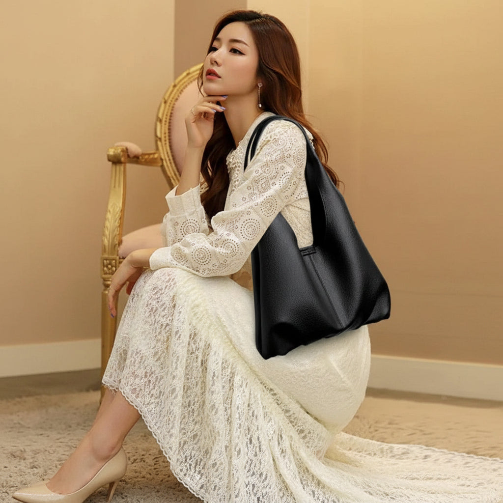 Elegant woman in white lace dress sitting with black leather shoulder bag and beige heels