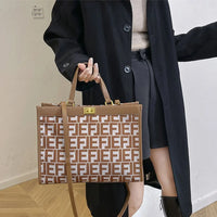 Woman in black coat holding large brown Fendi tote bag with monogram print indoors