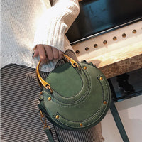 Green leather handbag with gold handles, casual outfit, modern fashion accessory