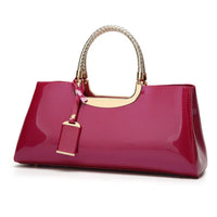 Glossy pink handbag with gold-tone handles and accent, white braided handle design