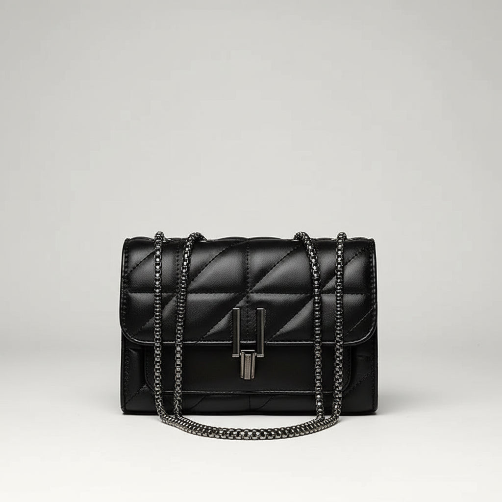 Black quilted leather handbag with chain strap and metal clasp on white background