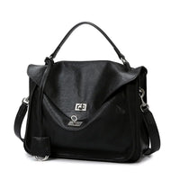 Black leather satchel handbag with top handle, flap closure and silver hardware on white background