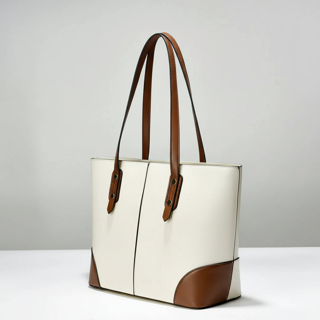 Two-tone leather tote bag with brown straps and white body on a plain background