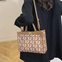 Woman in black coat carrying brown patterned tote bag with repeating F logo design indoors