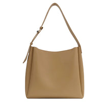 Minimalist tan leather shoulder bag with a single adjustable strap on a white background
