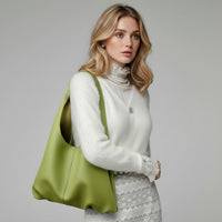 Woman with green leather tote bag, white sweater, and lace skirt, fashion accessory style