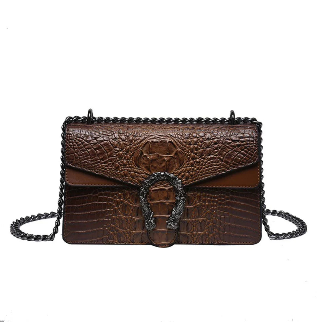 Brown crocodile-embossed leather shoulder bag with black chain strap and ornate metal buckle