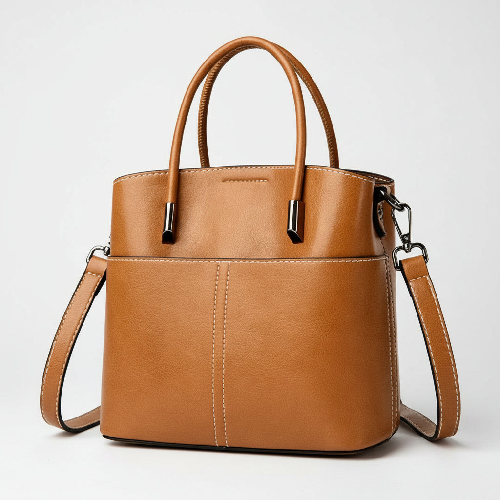 Brown leather handbag with top handles and detachable shoulder strap on white background