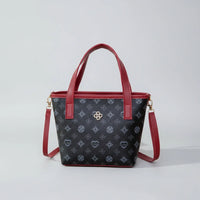 Black handbag with red handles, floral pattern, gold logo, and detachable shoulder strap
