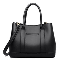 Black leather tote bag with double handles and detachable shoulder strap on white background