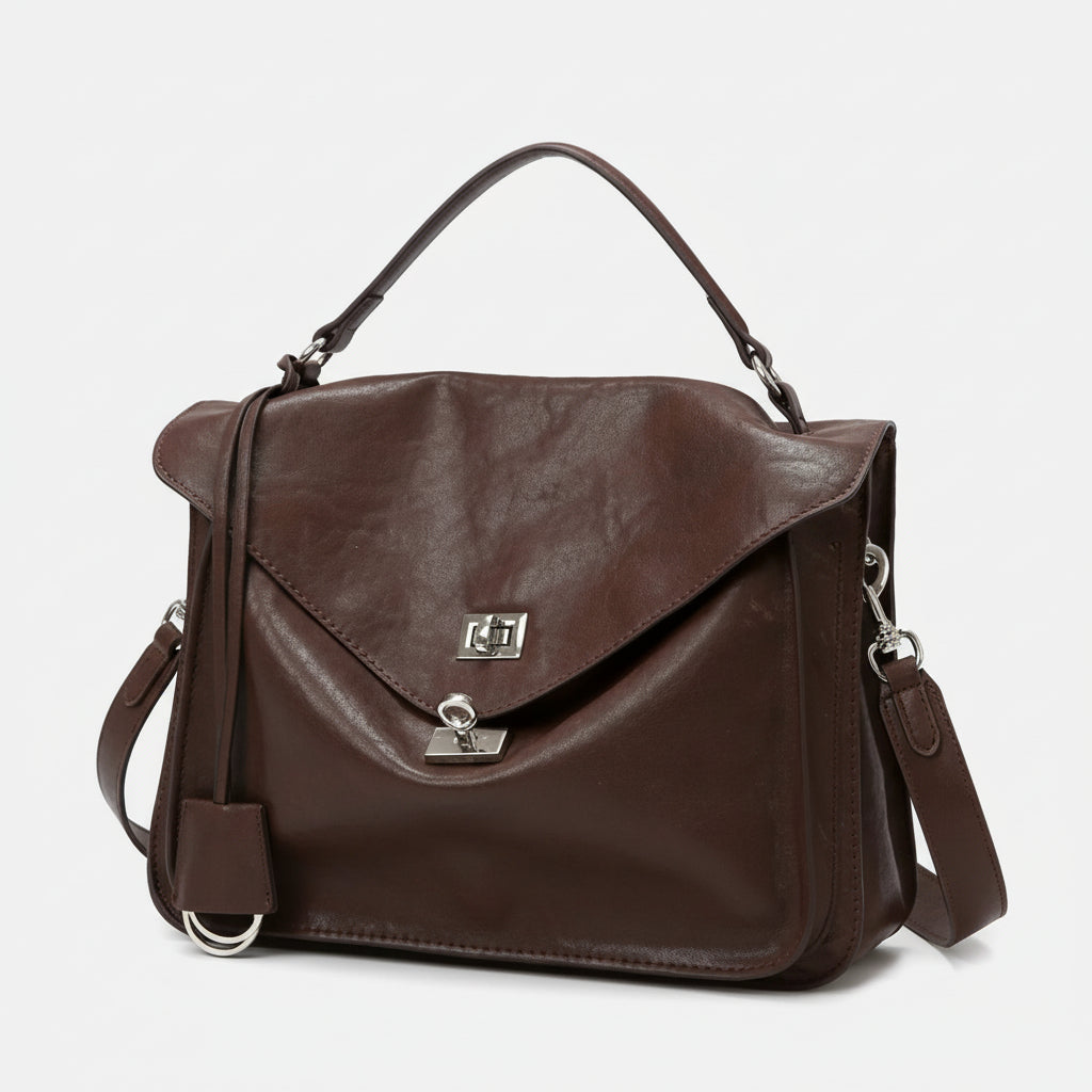 Brown leather satchel handbag with top handle, silver clasp, and detachable strap on white background