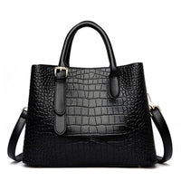 Black crocodile-embossed leather handbag with gold hardware and detachable strap
